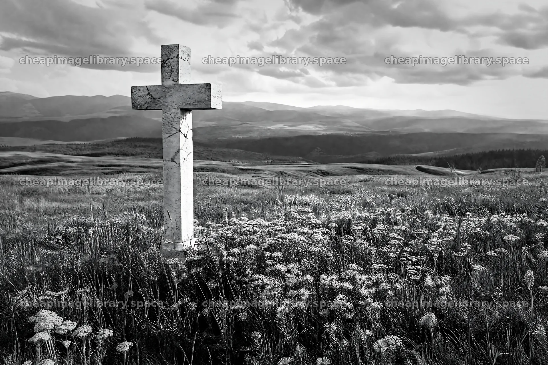Marble Christian cross in green meadow under cloudy sky – image library 9722x6480