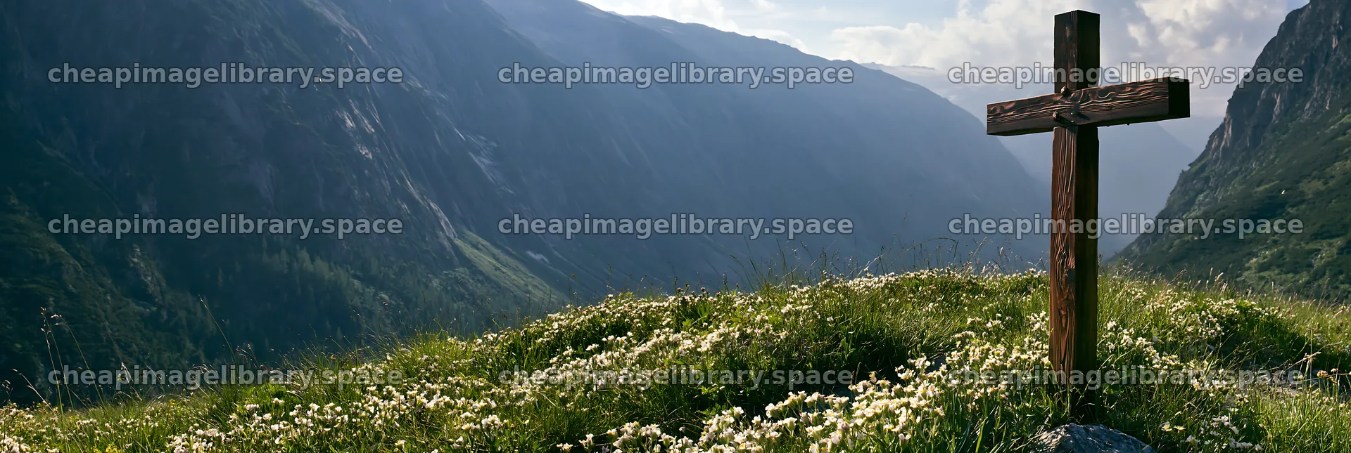 Wooden Christian cross in mountain meadow with flowers – image library 13690x4602