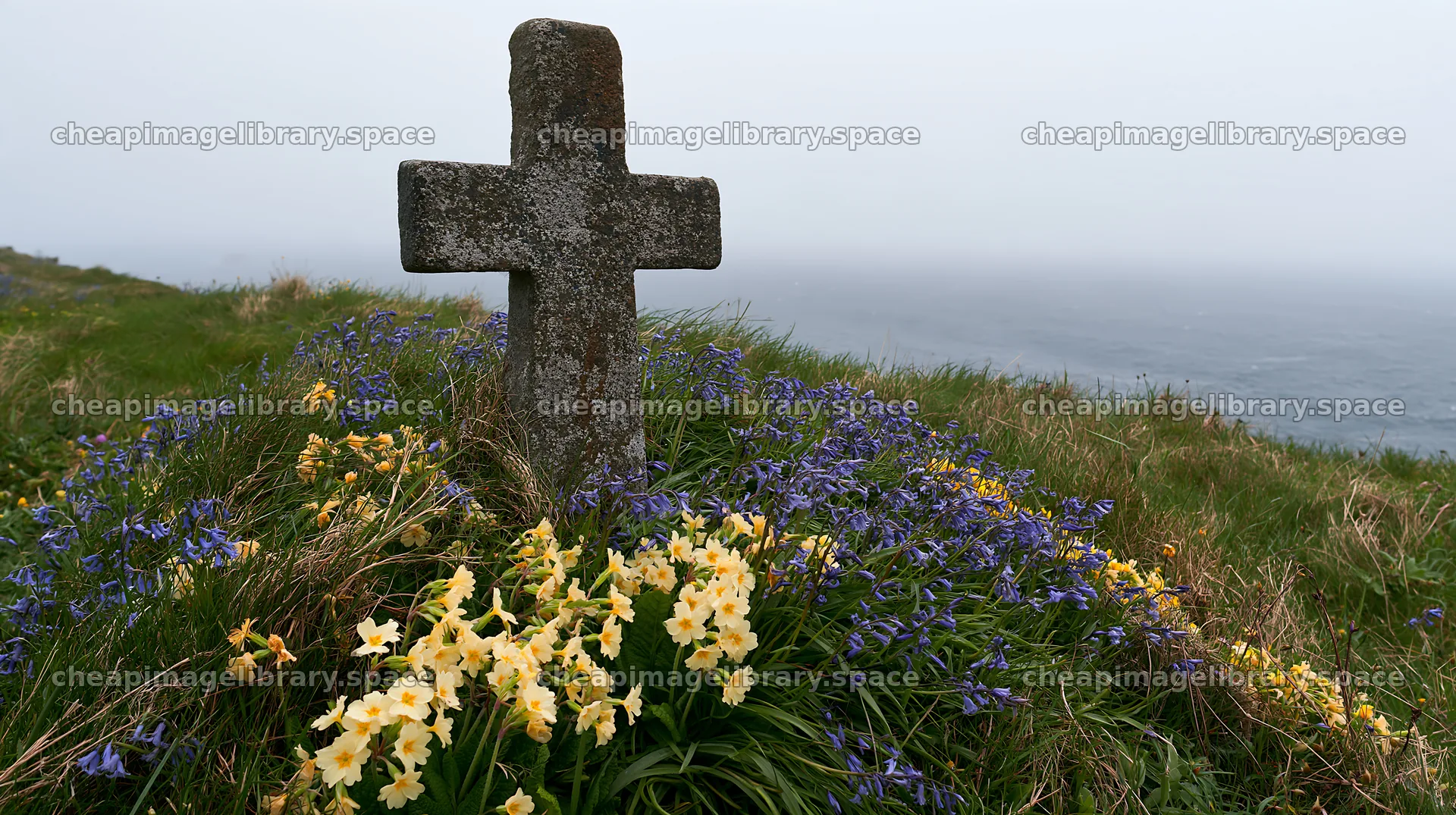 Rustic Christian cross surrounded by flowers in winter meadow – image library 10608x5938