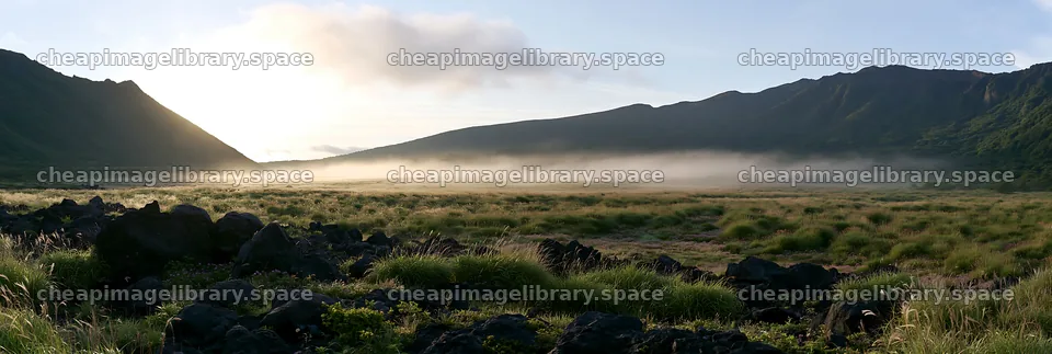 Kumamoto volcanic meadow dark rock foreground with green grass – image library 13690x4602