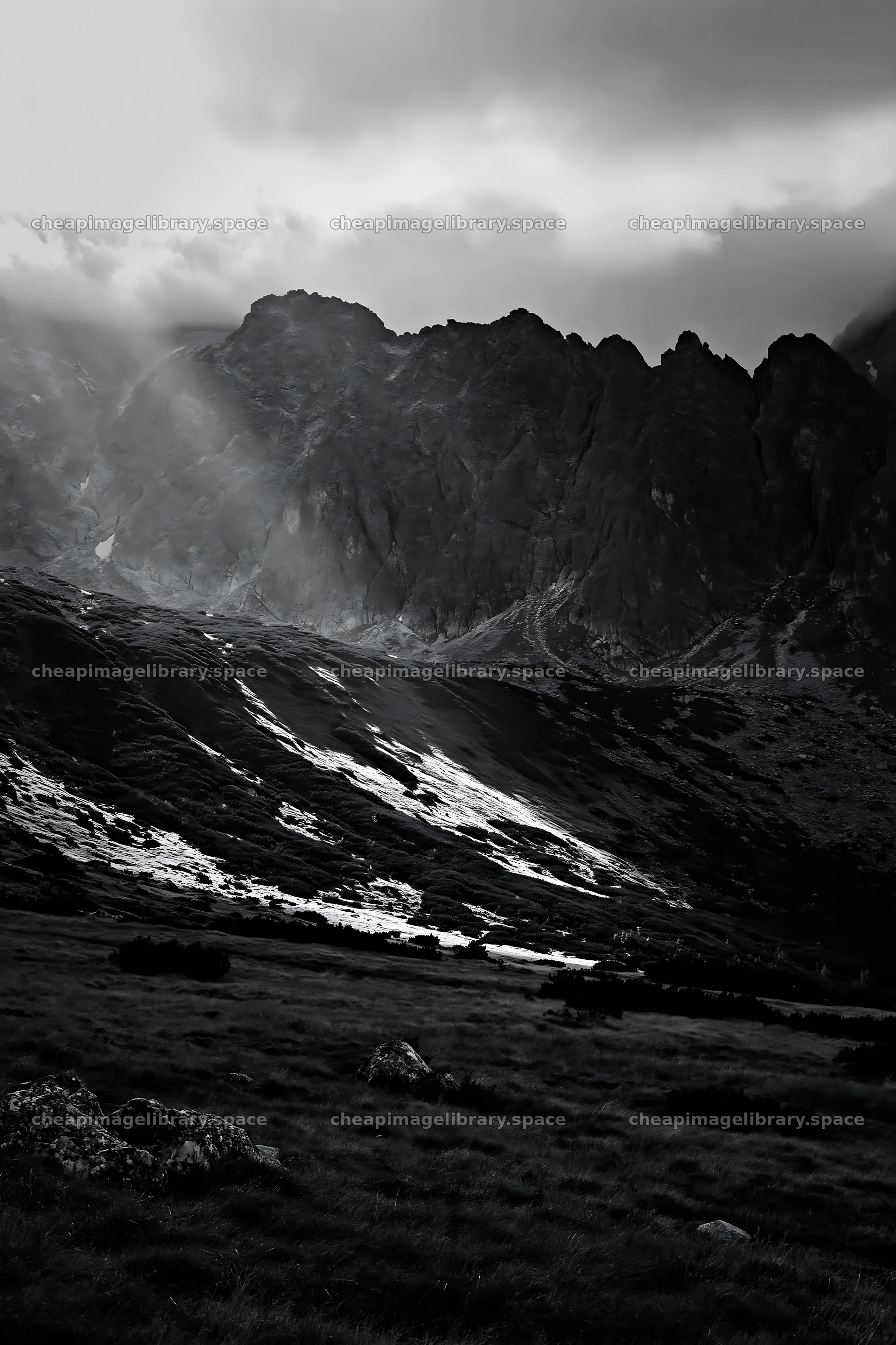 Meadow with mountains and sunrays shining through clouds – image library 6480x9722