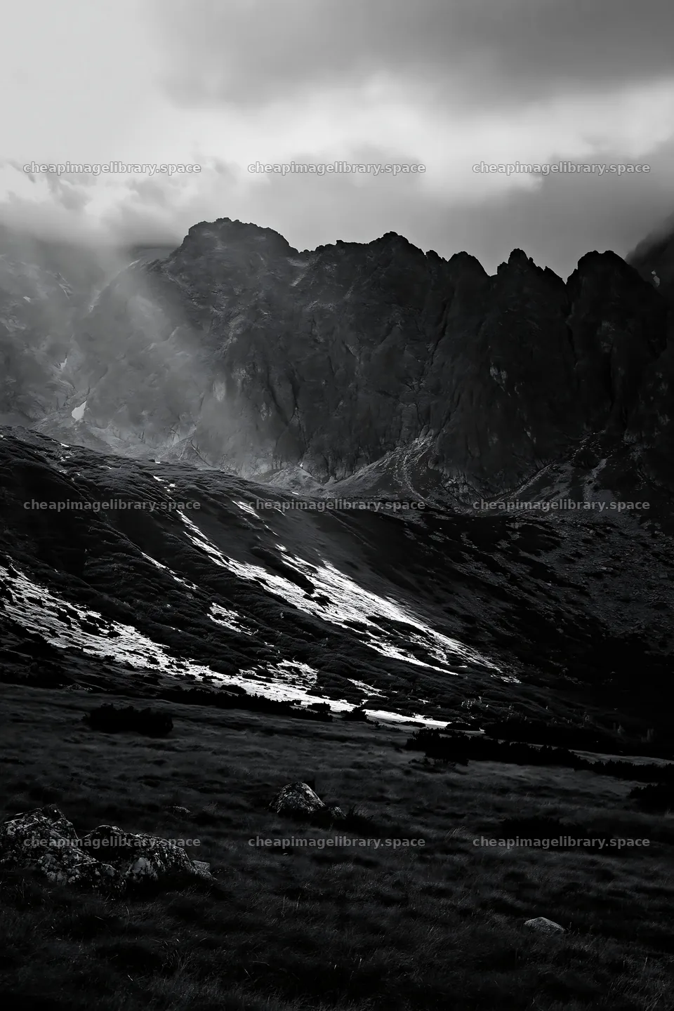 Meadow with mountains and sunrays shining through clouds – image library 6480x9722