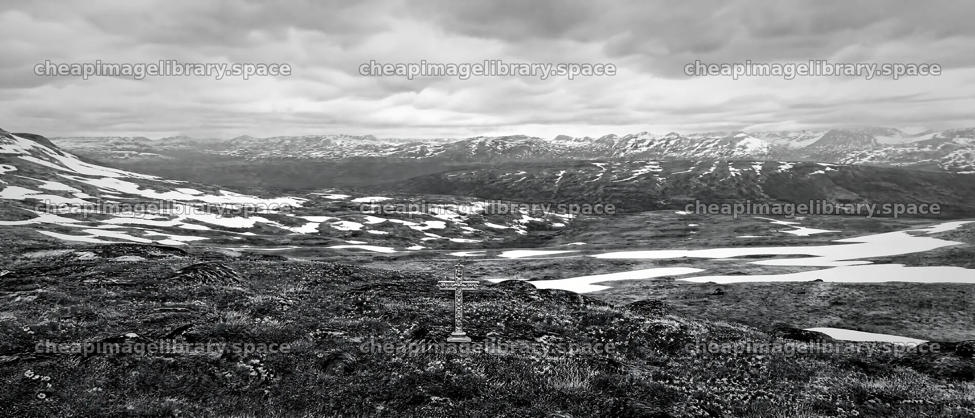 Christian cross in winter mountain meadow in deep valley – image library 12124x5196