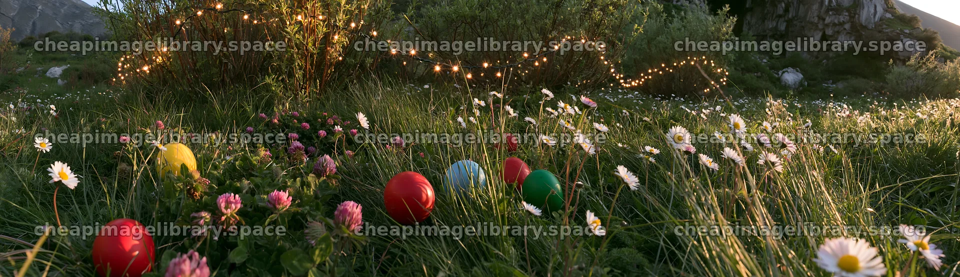Christmas ornaments in a meadow near a cave – image library 14762x4268