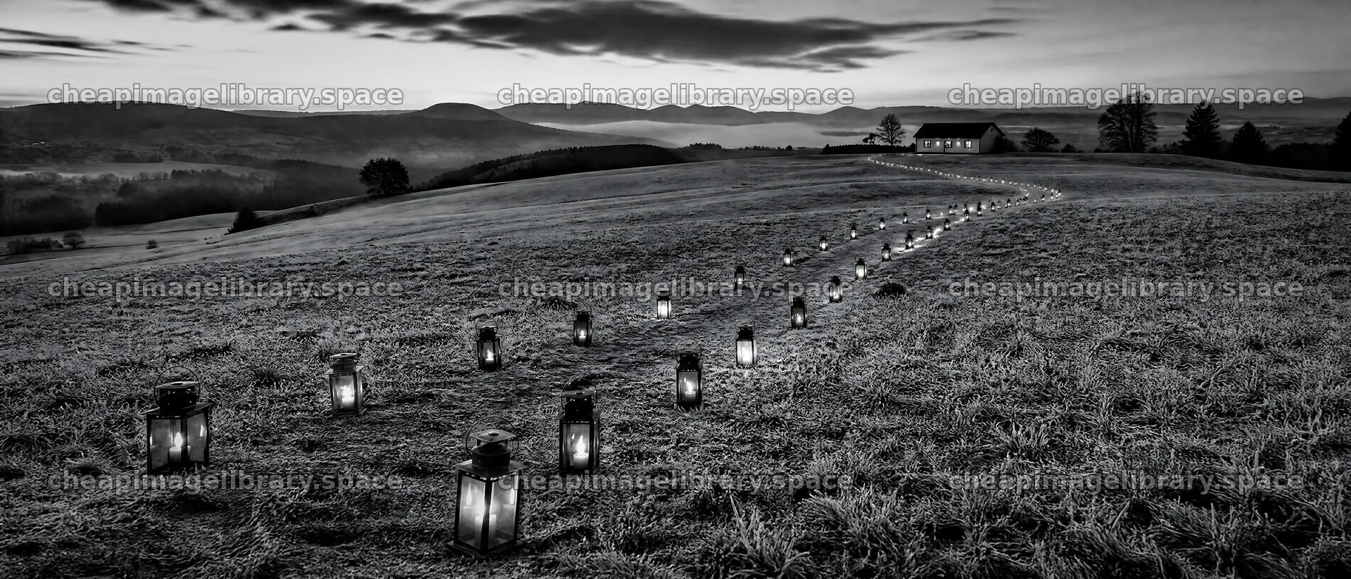 Colorful lanterns lighting a path across a meadow at dusk – image library 12124x5196